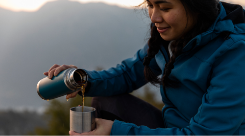 hiker pouring tea from canteen